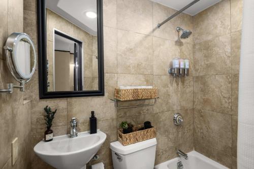 a bathroom with a sink and a toilet and a mirror at Stunning Apt in The Heart of New York City GYM in New York