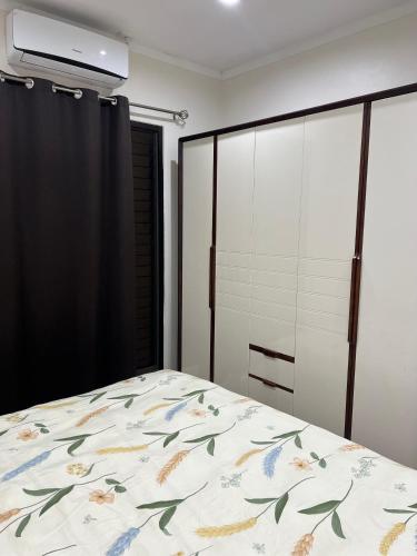 Elite Apartments في لوتوكا: غرفة نوم بها سرير مزين بغطاء سرير مزهر