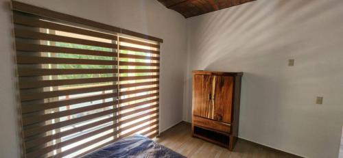 a bedroom with a window and a wooden dresser at Meztli Beach House in La Manzanilla