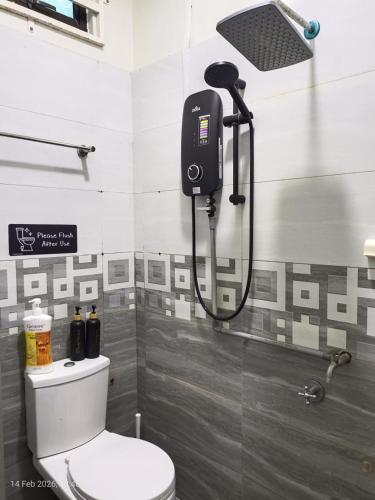 a bathroom with a shower and a toilet in it at D'Beris Homestay in Bachok