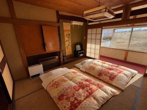 a bedroom with two beds and a window at HOTEL MtFuji MOMO AUNG 桃庵 in Yamanakako
