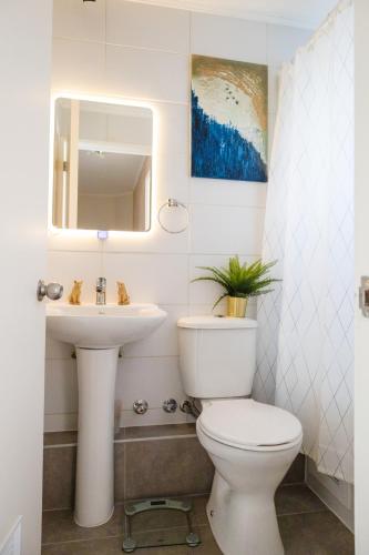 a bathroom with a toilet and a sink at Acogedora casa cerca del mar in San Pedro de la Paz