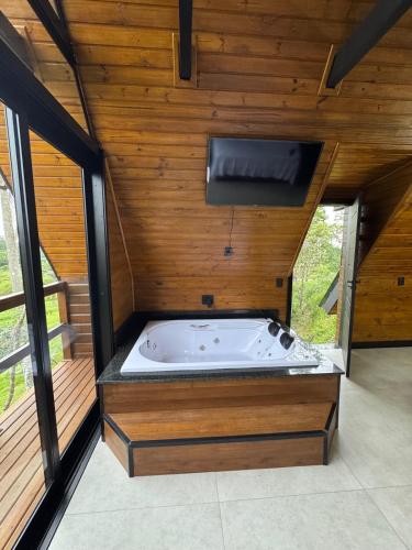 a jacuzzi tub in a room with wooden walls at Refúgio do Morro - cabana 2 in Torres