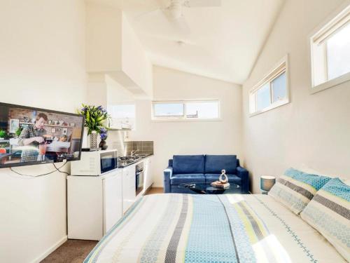 a bedroom with a large bed and a kitchen at McKillop Geelong by Gold Star Stays in Geelong