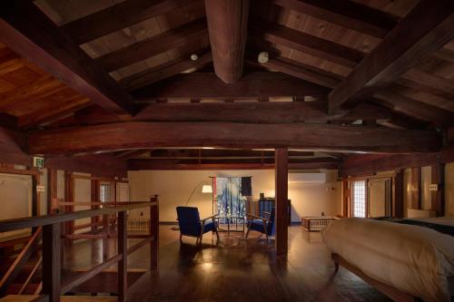 a room with a bed and a table and chairs at 泊まれる文化交流施設 盆宿U bon-yadoU in Nishimonai