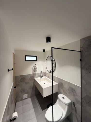 a bathroom with a sink and a toilet and a mirror at Aerobeach Apartments in Cartagena de Indias