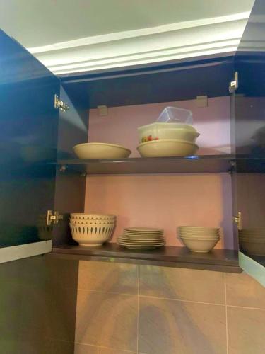 a display case with bowls and plates on a shelf at Afia Cottage Inn in Ayaso