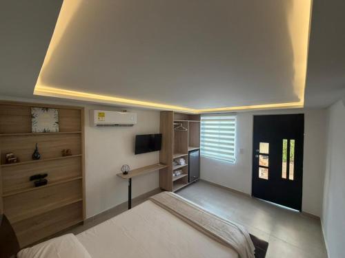 a bedroom with a bed and a desk and a television at Aerobeach Apartments in Cartagena de Indias