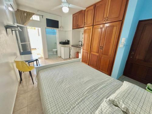 a bedroom with a bed and a table and a kitchen at PC 5 a 50 mts de la playa in Río San Juan
