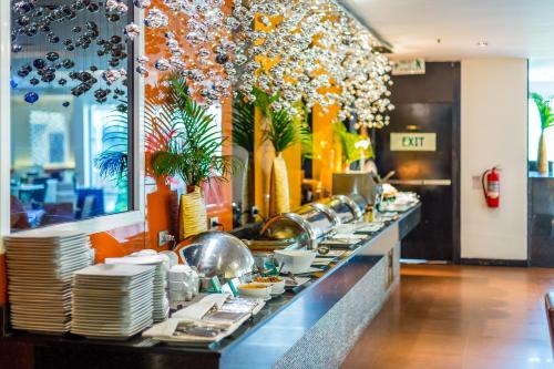 a buffet line with plates and dishes in a restaurant at Nova Platinum Hotel in Pattaya South