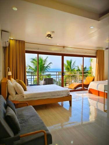 a bedroom with two beds and a view of the ocean at The Philip Ann Resort in Mabini