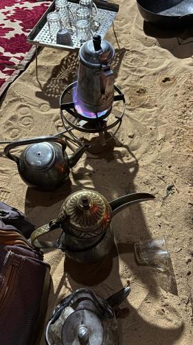a tea kettle on a stove in the sand at Red sand tent in Disah