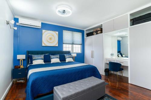 a blue bedroom with a bed and a chair at Paradise Haven Saint Lucia in Corinthe