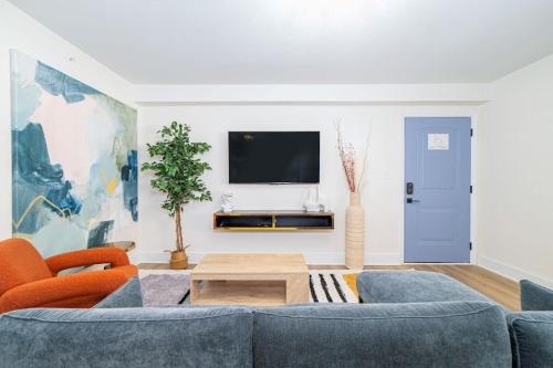 a living room with a blue couch and a tv at Sojourn's Harborage 2 BR 1 BA in Norfolk