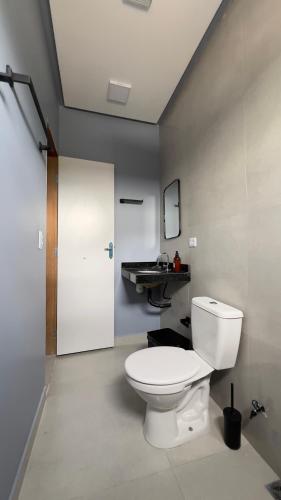 a bathroom with a white toilet and a sink at Hotel e Restaurante Santa Isabel in São Raimundo Nonato
