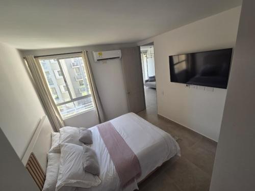 a bedroom with a bed and a flat screen tv at Sueños de Serena del Mar in Cartagena de Indias