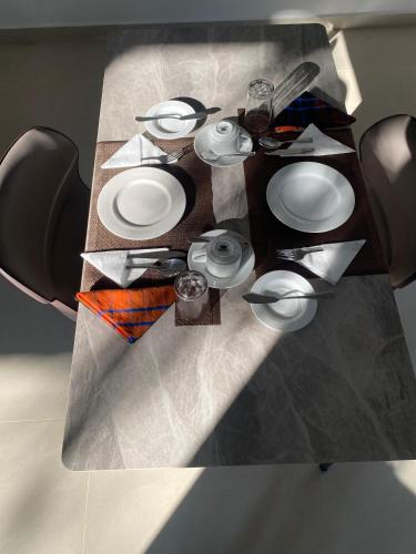a table with white plates and utensils on it at Sun Top Grand in Ella