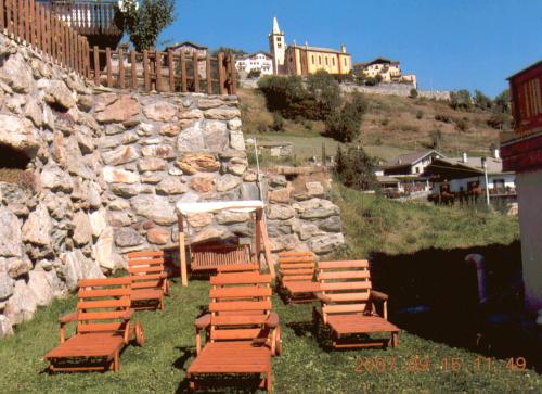 a group of chairs sitting in front of a stone wall at Affittacamere De Charme Jour Et Nuit in Torgnon