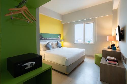 a bedroom with a bed and a tv in it at KHAS Surabaya Hotel in Surabaya