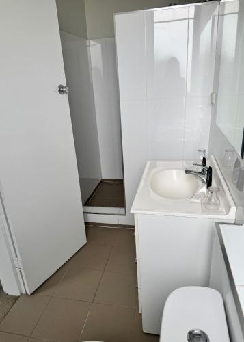 a white bathroom with a sink and a toilet at Amaroo Hotel Dubbo in Dubbo