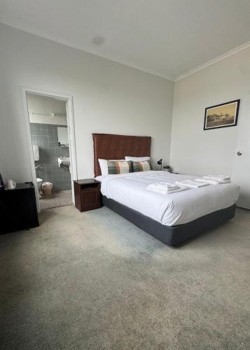 a bedroom with a large bed and a bathroom at Amaroo Hotel Dubbo in Dubbo