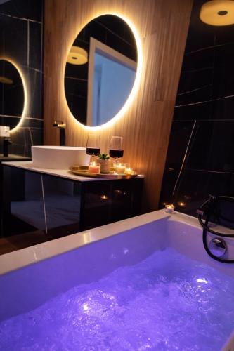 a bath tub filled with purple water in a bathroom at Romantic Sea View Studio with Jacuzzi in Alicante Center in Alicante