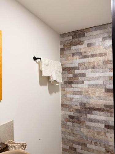 a bathroom with a brick wall with a towel on the wall at Almada - Casas de Campo in Baradero