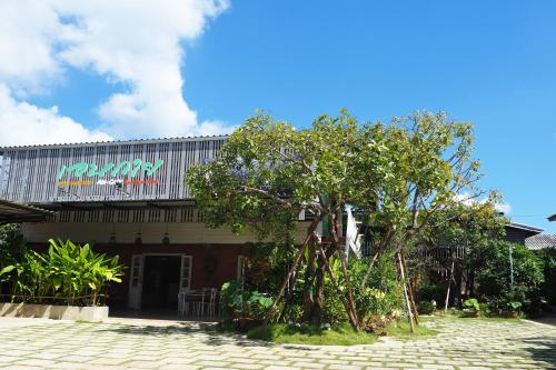 a building with a tree in front of it at Aen Guy Boutique Hotel in Sukhothai