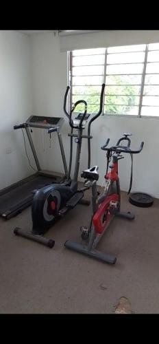 a gym with two exercise bikes and a treadmill at Dodig in Chincha