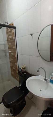 a bathroom with a toilet and a sink and a mirror at Villa sonhos in Belém