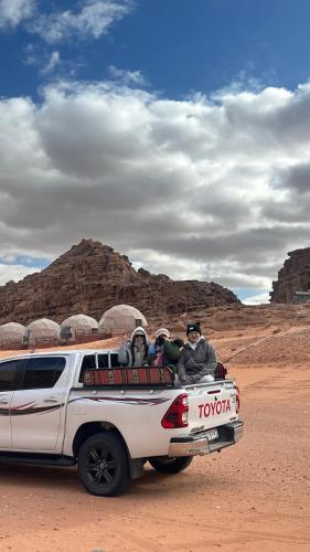 two people in the back of a truck in the desert at Moon view in Disah