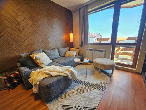a living room with a couch and a large window at One-Bedroom Apartment with Balcony & Fast WiFi in Bansko