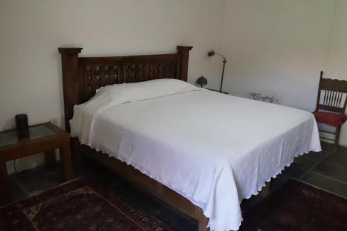 a bedroom with a white bed and a red chair at Hacienda Bugambilias Boutique Colonial in Cedro