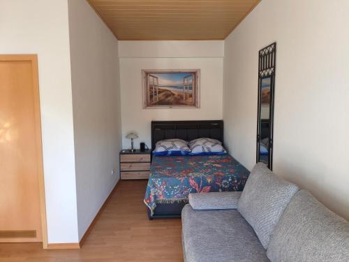 a bedroom with a bed and a couch at Lahnzauber Obernhof in Obernhof