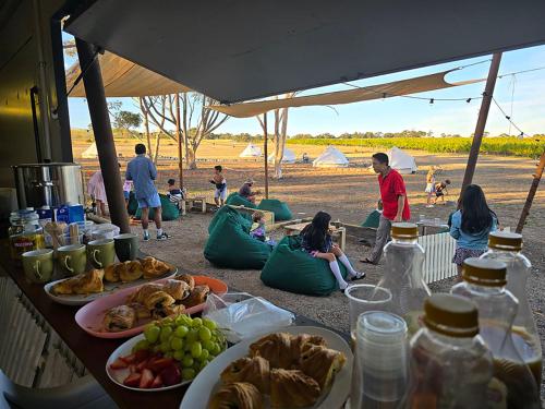a group of people sitting around a table with food at Coastal Glamp at Bellarine Estate winery in Bellarine