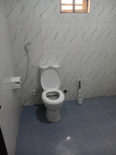 a white bathroom with a toilet in a room at Olori apartments in Adeleye