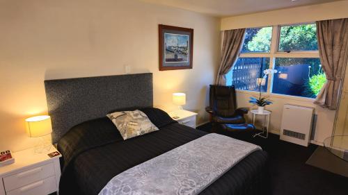 a bedroom with a large bed and a window at Mount View Motel Hawera in Hawera