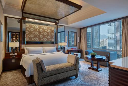 a bedroom with a large bed and a living room at Futian Shangri-La, Shenzhen in Shenzhen
