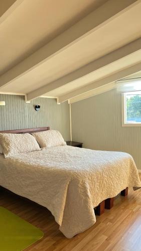 a large bed in a bedroom with a window at Hospedaje Avenida in Puerto Montt