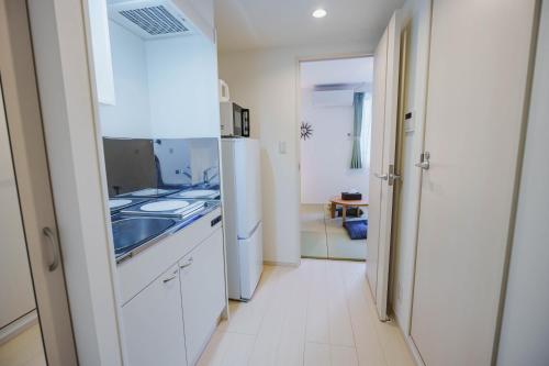 a kitchen with a sink and a refrigerator at QH202 New Tokyo Apartment, Direct access to Ueno, Asakusa, Disneyland, Airport in Tokyo