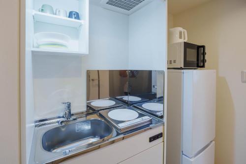 a kitchen counter with a sink and a stove at QH202 New Tokyo Apartment, Direct access to Ueno, Asakusa, Disneyland, Airport in Tokyo