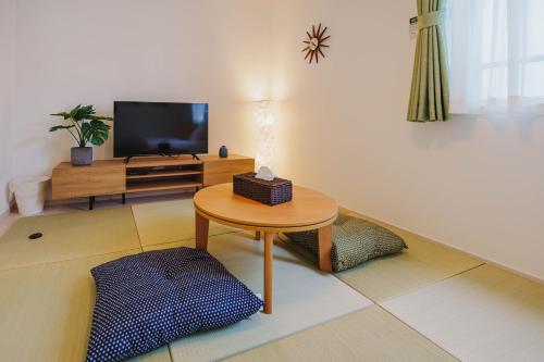 a living room with a table and a flat screen tv at QH202 New Tokyo Apartment, Direct access to Ueno, Asakusa, Disneyland, Airport in Tokyo