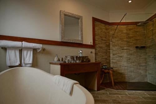 a bathroom with a large tub and a shower at Villa Kelapa Candidasa in Candidasa