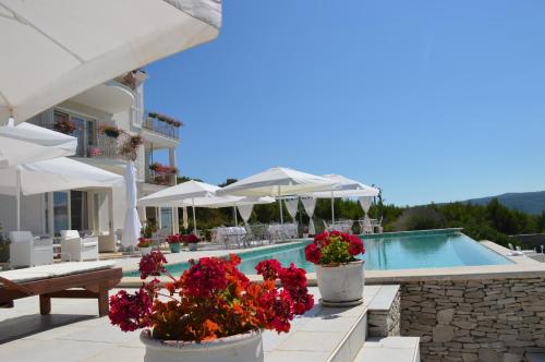 une villa avec une piscine et des fleurs en pots dans l'établissement VILLA STEFANIJA small Boutique hotel&restaurant, à Barban