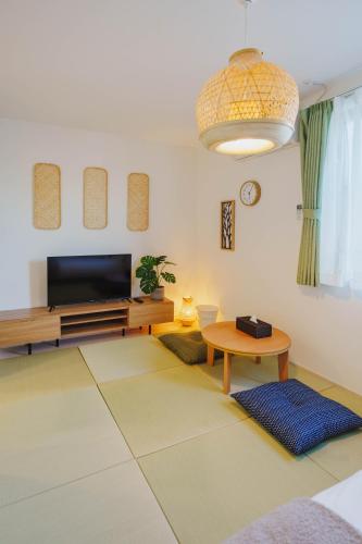 a living room with a television and a table at QH302 New Tokyo Apartment, Direct access to Ueno, Asakusa, Disneyland, Airport in Tokyo
