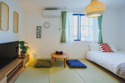 a bedroom with a bed and a table and a tv at QH302 New Tokyo Apartment, Direct access to Ueno, Asakusa, Disneyland, Airport in Tokyo