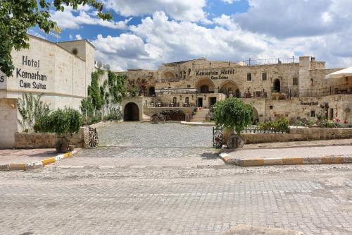 an old stone building with a courtyard in front of it at Kemerhan Cave Suites in Urgup