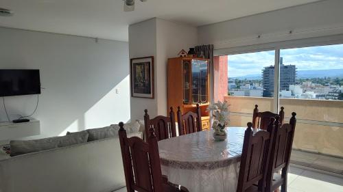 a dining room with a table and a large window at Torre del Lago in Villa Carlos Paz