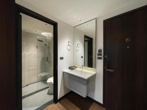 a bathroom with a sink and a shower and a toilet at Carista Hotel in Vientiane