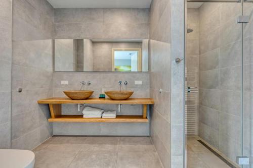 a bathroom with two sinks and a shower at Duinvilla Noordwijk in Noordwijk